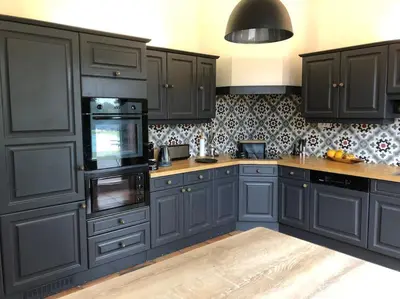 a kitchen with dark blue cabinets and a counter at Proche Aix-en-Provence maison avec piscine - 10 personnes in Rognes
