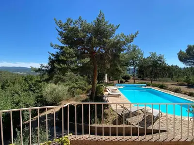 a swimming pool with chairs next to a fence at Villa Les Gourdeaux in Roussillon