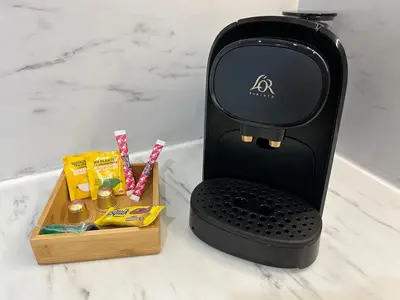 a black espresso machine sitting on a counter with a box of candy at Studio cosy avec mezzanine in Salon-de-Provence