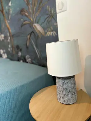 a lamp sitting on a table next to a bed at Villa Mirabelle 4 personnes in Châteauneuf-de-Gadagne