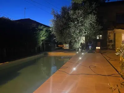 a swimming pool in a yard at night at Maison idéale pour famille proche de toutes commodités in Carpentras