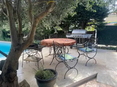 a patio with a table and chairs next to a tree at Maison idéale pour famille proche de toutes commodités in Carpentras