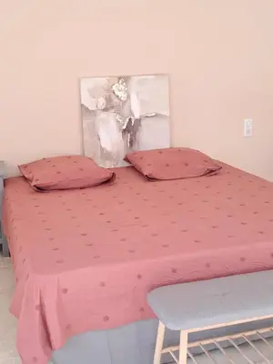 a pink bed with a pink comforter and a chair at Villa SOFIA in Saint-Saturnin-les-Apt