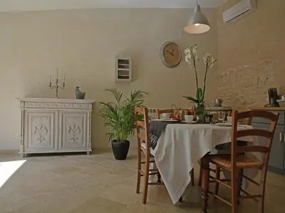 a dining room with a table and chairs and a clock at Farmhouse in Carpentras with Pool in Carpentras