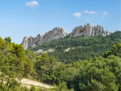 a mountain with trees and rocks in the background at Farmhouse in Carpentras with Pool in Carpentras