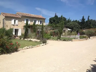 a stone house with a yard and a driveway at Farmhouse in Carpentras with Pool in Carpentras
