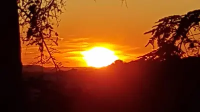 a sunset with the sun setting in the background at chambre d'hote de charme 