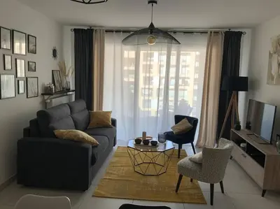a living room with a couch and a chair at Logement cosy climatisé avec parking in Aix-en-Provence