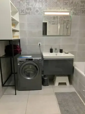 a bathroom with a washing machine and a sink at Logement cosy climatisé avec parking in Aix-en-Provence