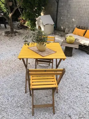 a yellow table and bench with a potted plant on it at Parenthèse caumontoise . in Caumont-sur-Durance