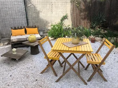 a picnic table and two chairs and a couch at Parenthèse caumontoise . in Caumont-sur-Durance