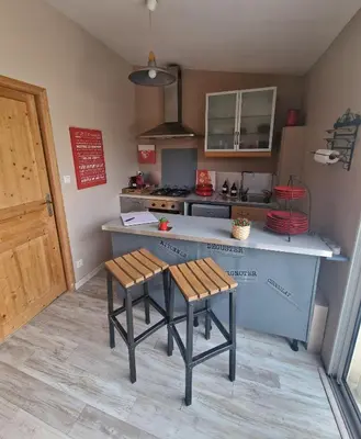 a kitchen with a counter and two stools in it at Parenthèse caumontoise . in Caumont-sur-Durance