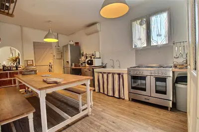 a kitchen with a wooden table and a stove at Les copains d'abord ! in Lacoste
