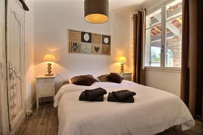 a bedroom with a white bed with two pillows on it at Les copains d'abord ! in Lacoste
