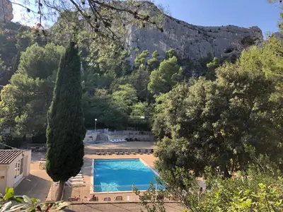 a swimming pool with a mountain in the background at Camping maeva Respire La Vallée Heureuse in Orgon