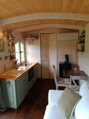 a kitchen with a sink and a couch in a room at Roulotte Karlotte in Pernes-les-Fontaines
