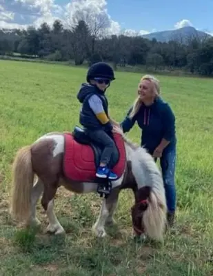 a woman and a child riding on a horse at nuitée à la ferme in Jouques