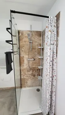 a bathroom with a shower with a shower curtain at La Grange des Joumillons in Saint-Saturnin-les-Apt