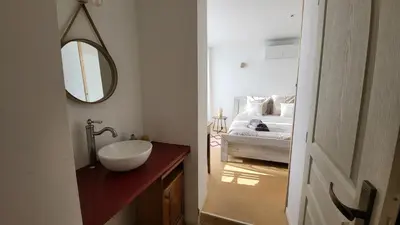 a bathroom with a sink and a bed with a mirror at La Grange des Joumillons in Saint-Saturnin-les-Apt
