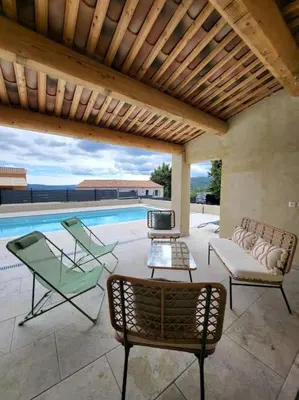 a patio with chairs and a swimming pool at La Grange des Joumillons in Saint-Saturnin-les-Apt