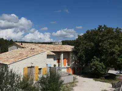 a white house with orange doors and a tree at La Grisonne - Gîte Camus in Revest-du-Bion