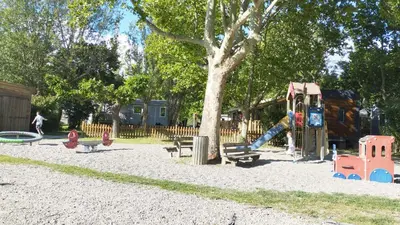 a park with a playground and a swing at Mobil Home vue sur le lac dans un camping 4 étoiles à Cadenet in Cadenet