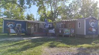 two mobile homes with a bear painted on them at Mobil Home vue sur le lac dans un camping 4 étoiles à Cadenet in Cadenet