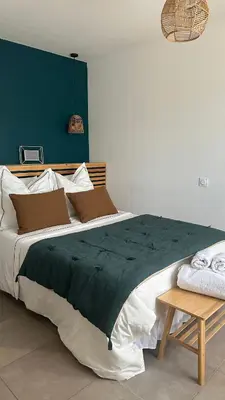 a bedroom with a large bed with a green blanket at Magnifique villa familiale avec piscine in Caumont-sur-Durance