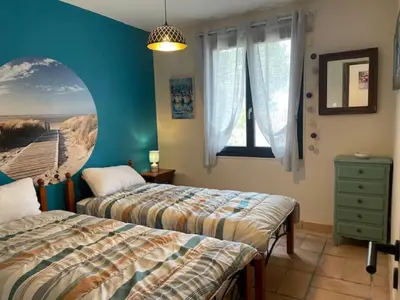 a bedroom with two beds and a window at Gîte de L'Embuissonnade in Montfuron