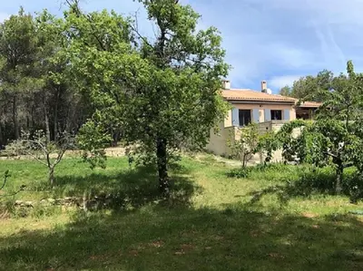 a house in the middle of a field with trees at Gîte de L'Embuissonnade in Montfuron