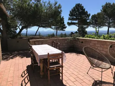 a table and chairs sitting on a brick patio at Gîte de L'Embuissonnade in Montfuron