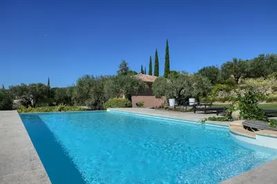 a swimming pool in a yard with trees and a house at Villa jeanne avec piscine Chauffée à Bedoin in Bédoin