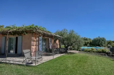 a house with chairs and a yard with a pool at Villa jeanne avec piscine Chauffée à Bedoin in Bédoin