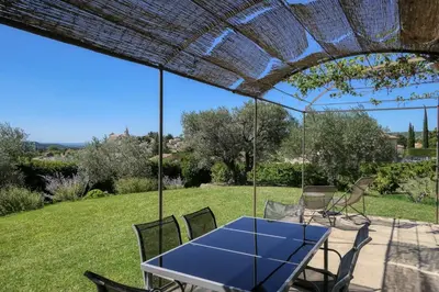 a table and chairs under a pergola at Villa jeanne avec piscine Chauffée à Bedoin in Bédoin