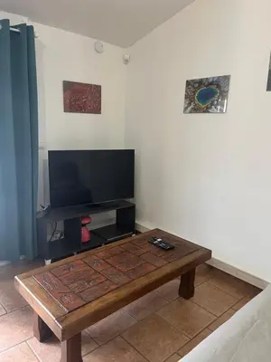 a living room with a coffee table and a flat screen tv at La Port-Gentillaise in Aix-en-Provence