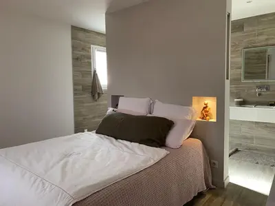 a bedroom with a bed and a bathroom with a sink at PERNO LI FONT villa contemporaine avec piscine in Pernes-les-Fontaines