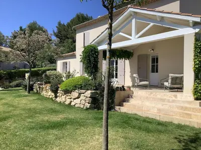 a white house with a porch and a lawn at PERNO LI FONT villa contemporaine avec piscine in Pernes-les-Fontaines
