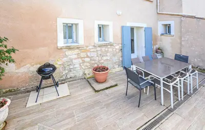 a patio with a table and chairs and a grill at Les Romarins dans le Mas de la PERRINE entre AVIGNON LUBERON Mt VENTOUX in Monteux