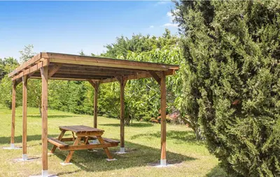 a picnic table and a wooden pavilion in a park at Les Romarins dans le Mas de la PERRINE entre AVIGNON LUBERON Mt VENTOUX in Monteux