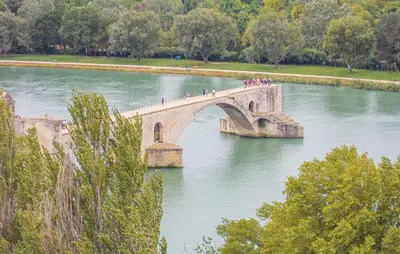 a group of people crossing a bridge over a river at Les Romarins dans le Mas de la PERRINE entre AVIGNON LUBERON Mt VENTOUX in Monteux