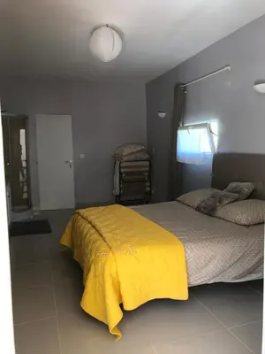 a bedroom with a bed with a yellow blanket at Maison au pied du mont ventoux in Carpentras