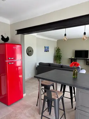 a living room with a red refrigerator and a table at Les Juliens in Gordes