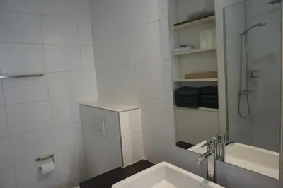 a white bathroom with a sink and a shower at Appartement Suite Privilège avec Parking in Salon-de-Provence
