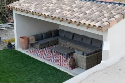 a couch sitting under a roof on a patio at Comme à la maison in Châteauneuf-de-Gadagne