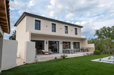 a white house with a green yard at Comme à la maison in Châteauneuf-de-Gadagne
