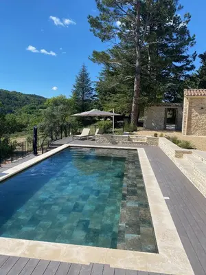 a swimming pool with a table and an umbrella at Magnifique Mas avec Piscine Luberon (Gordes) in Murs