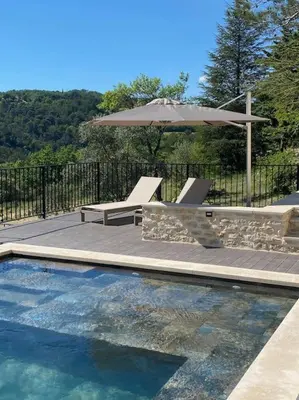 a pool with a table and an umbrella and a bench at Magnifique Mas avec Piscine Luberon (Gordes) in Murs