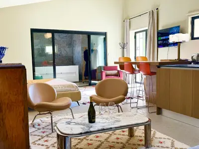 a room with chairs and a table with a bottle of wine at La palasse in Le Thor