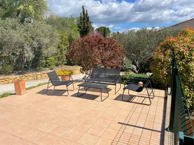 a patio with two chairs and a bench on it at Studio charmant avec terrasse in Lançon-Provence
