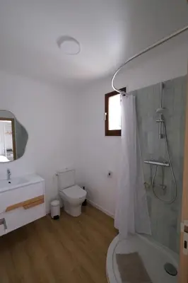 a white bathroom with a toilet and a shower at Rouleraventoux, Gîte sportif avec piscine, sauna, salle de sport, jardin in Mormoiron